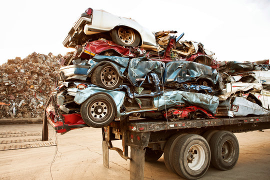 Stack of crushed cars on trailer at junkyard