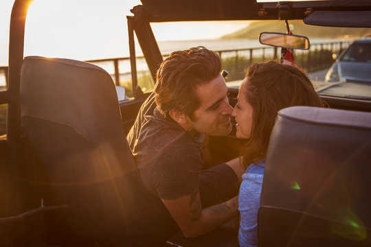 Happy couple kissing in pick-up truck