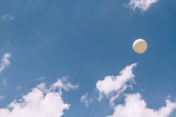 White Balloon Flying in a Perfect Cloudy Blue Sky © OZMedia