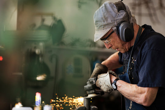 Senior man using circular saw in workshop