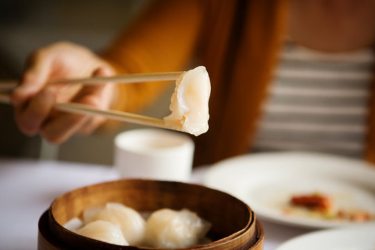 Close-up of hand holding chopsticks with Chinese dumpling