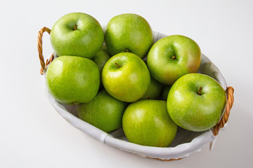 Wooden vintage basket full of green Granny Smith apples at white background