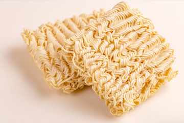 Uncooked instant noodles on white marble background