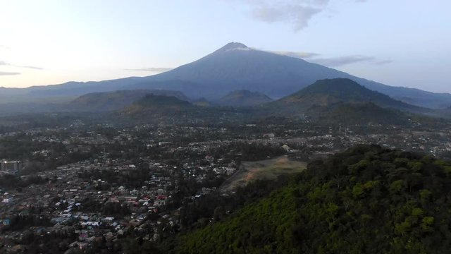 Aerial View of a Huge Mountain Looming in the Distance from a Rural Village in Tanzania