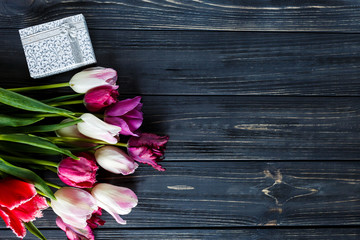 colorful tulips, wite  box on the gray wooden table. Valentines, spring background. floral mock up.  with copyspace