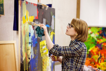 Side view of woman painting on canvas at studio © Cavan for Adobe