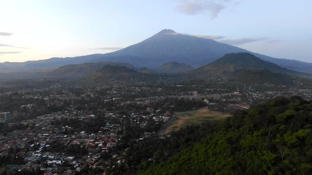 Drone Shot of a Huge Mountain Next to an African Village, Backwards Flying Motion