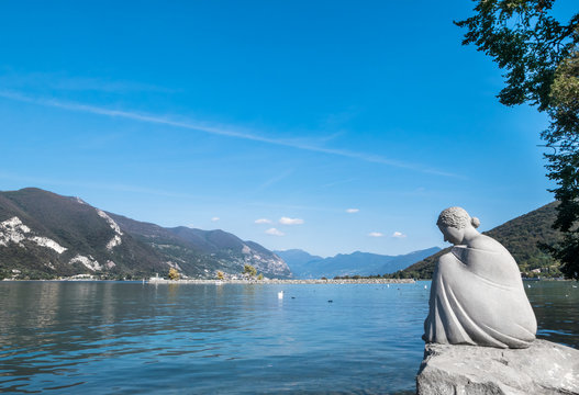 Sculpture of a young woman sitting on a rock