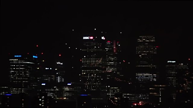 UK November 2018 - Slow motion of a barrage of fireworks exploding in front of Canary Wharf financial district in London at night.