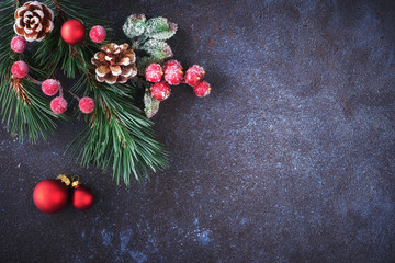 Christmas background: corner decorated with fir twigs, berries and Christmas baubles on dark, copy-space