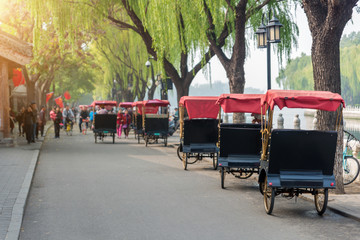 Tourists riding Beijing traditional rickshaw in old China Hutongs in Beijing, China.