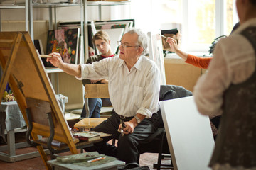 Painter teaching students at art studio © Cavan for Adobe
