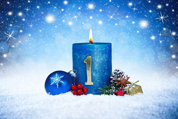 first sunday of advent blue candle with golden metal number red decoration one on wooden planks in...