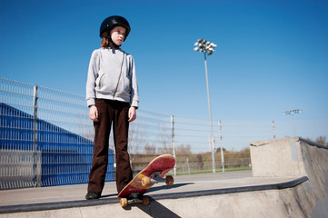 Girl with skateboard looking away while standing at park © Cavan for Adobe
