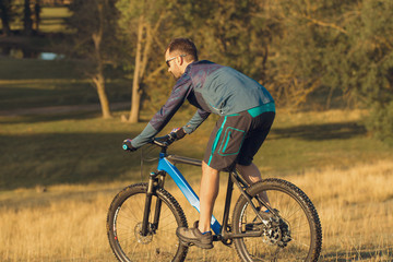 Obraz premium Cyclist in shorts and jersey on a modern carbon hardtail bike with an air suspension fork