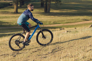 Cyclist in shorts and jersey on a modern carbon hardtail bike with an air suspension fork