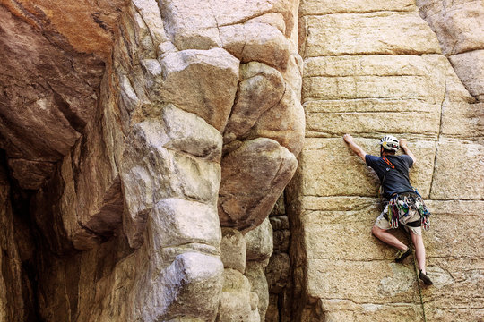Rear view of rock climber climbing on mountain