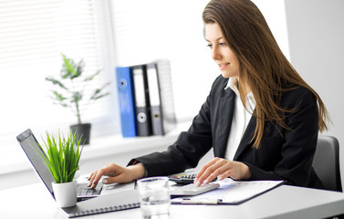 Image of young business woman working on project at office