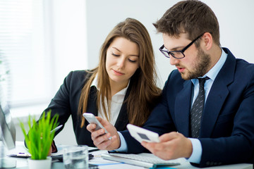 Young businessman discussing something with his colleague, and using a digital tablet together
