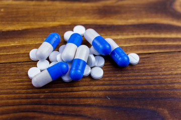 Pile of pills on the wooden background