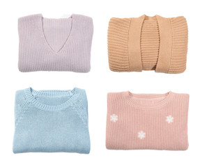 Set of folded warm sweaters on white background