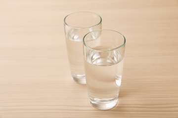 Glasses of fresh water on wooden table