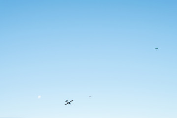 View of the blue sky with airplane and people are skydiving.