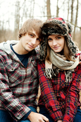 Fototapeta premium Portrait of young couple wearing warm clothing in forest