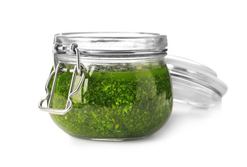 Homemade basil pesto sauce in glass jar on white background