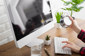Modern designer sitting in front of computer in office