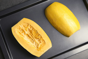 Baking tray with cut spaghetti squash on table