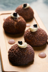 Chocolate profiteroles with peach violet. Cake Brioche shu cream