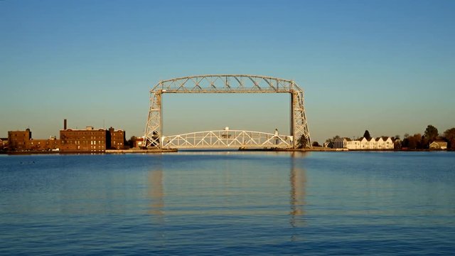 Two clips of the Iconic Duluth Minnesota Aerial Lift Bridge and Duluth Harbor on a calm sunny afternoon under blue skies.