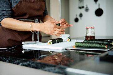 Midsection of woman making maki sushi at home © Cavan for Adobe