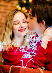 Fine couple tangled with garlands hugging each other