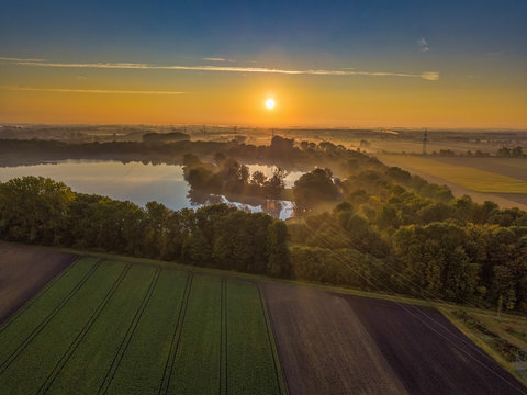 Flug &uuml;ber den Feringssee am Morgen mit Nebel, der das gelbe Sonnenlicht bricht