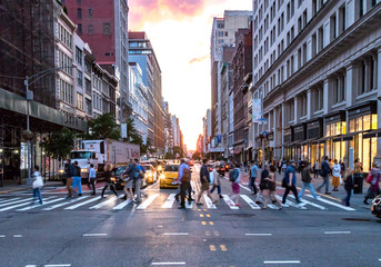 New York City - juni, 2018: Menigten van diverse mensen steken het drukke kruispunt op 23rd Street en 5th Avenue in Manhattan over met spitsuurverkeer op de achtergrond.