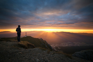Obraz premium Man standing on mountain during sunset