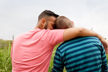 Rear view of homosexual couple sitting against clear sky