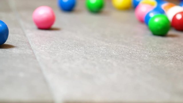 Gumballs roll on counter, close up