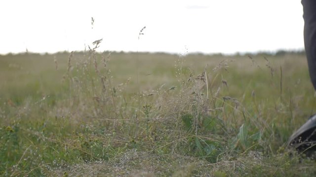 Man in a black suit picking up a guitare from the ground