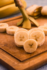 Sliced ripe banana with peeled on wooden background.