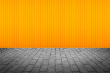 Outdoor stone block tile floor texture with yellow metal wall background.