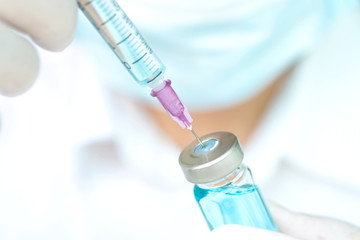 Hand of doctor holding syringe and medicine bottle. Preparing for injection