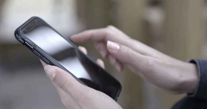 Browsing and texting on the phone, outdoors &ndash; 4K