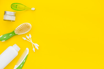 Children's personal care kit. Bath accessories with teeth brush on yellow background top view copy space