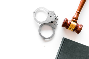 Crime concept. Metal handcuffs near judge gavel and law book on white background top view copy space