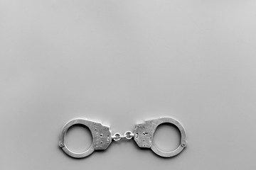 Metal handcuffs on grey background top view copy space
