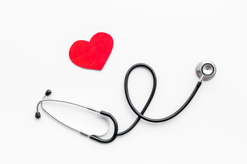 Heart disease concept. Stethoscope near heart sign on white background top view