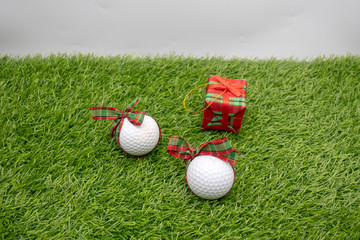 Naklejka premium Golf ball with Christmas Present are on green grass